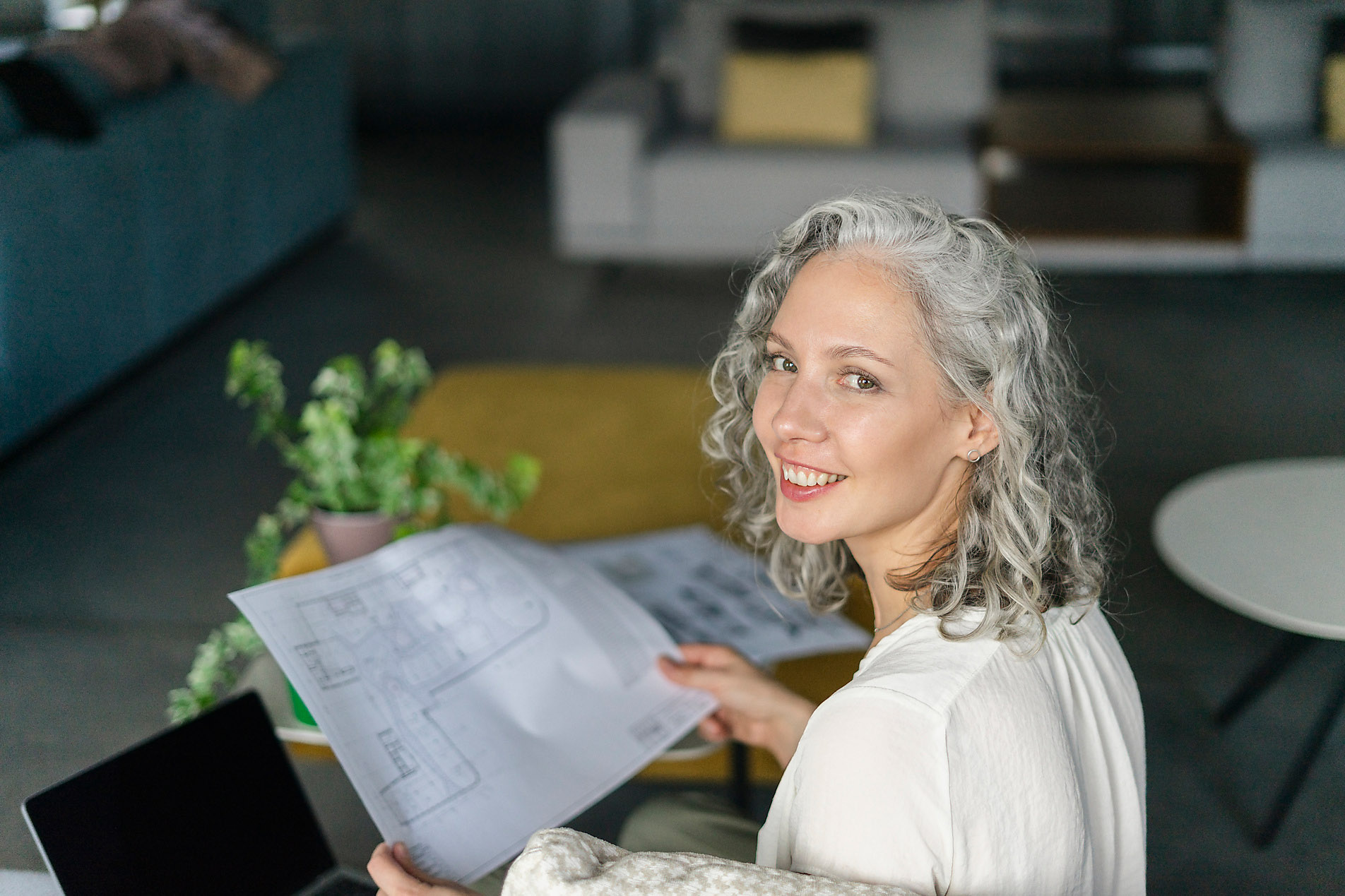 Portrait of smiling female architect holding floor plan, office, green architecture, sustainability, Westend61, stock photo royalty free