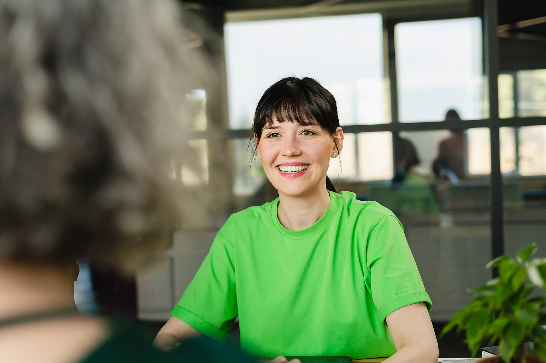 Smiling woman with colleague in green t-shirt in office, stock photo, royalty free, sustainability, stock photography beginner, stock photo, royalty free