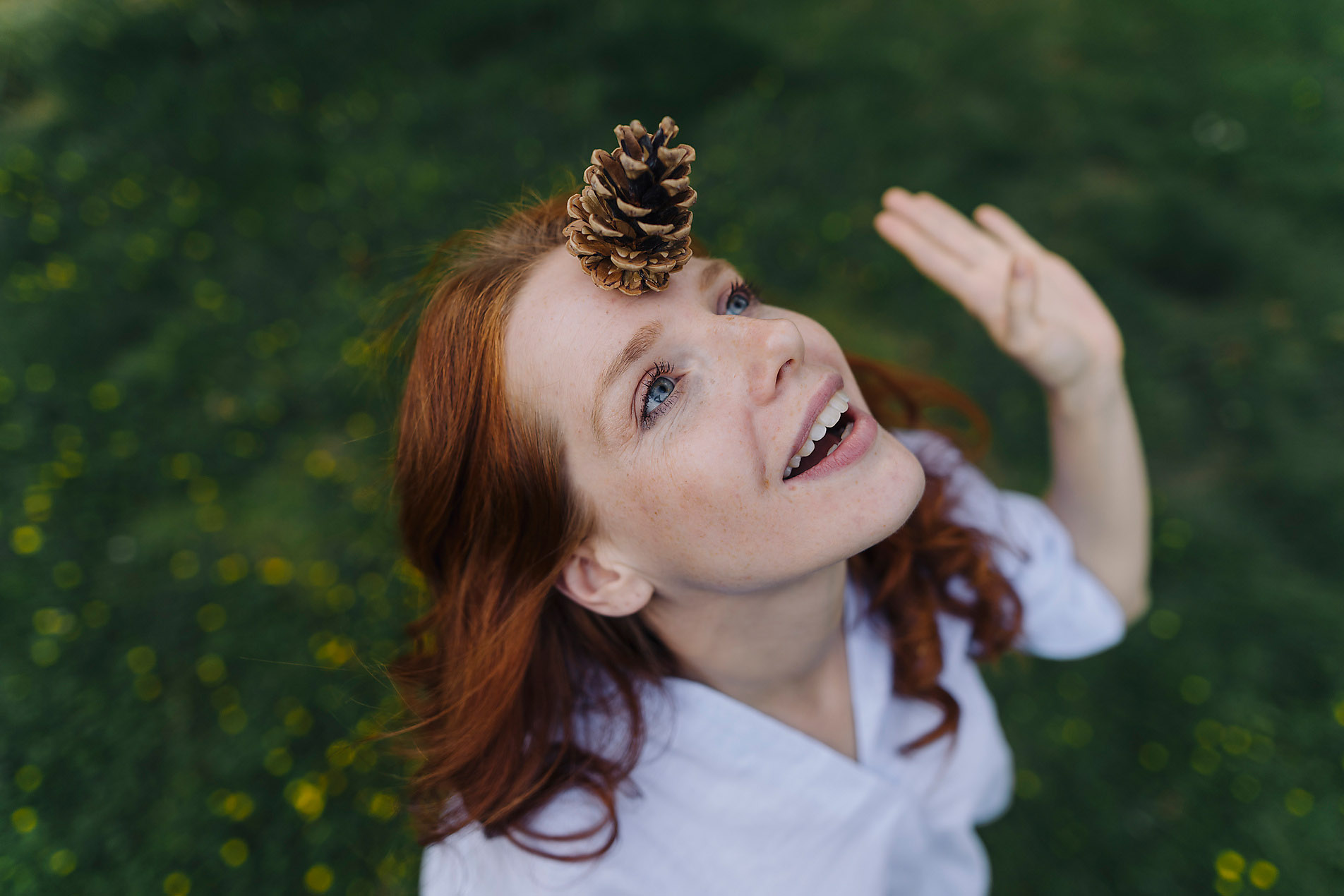 Stock photo, royalty free, Redheaded woman standing in a green field balancing a pine cone on her forehead, resilience, balance, equilibrium, mindfulness, mental strength, Westend61, Joseffson