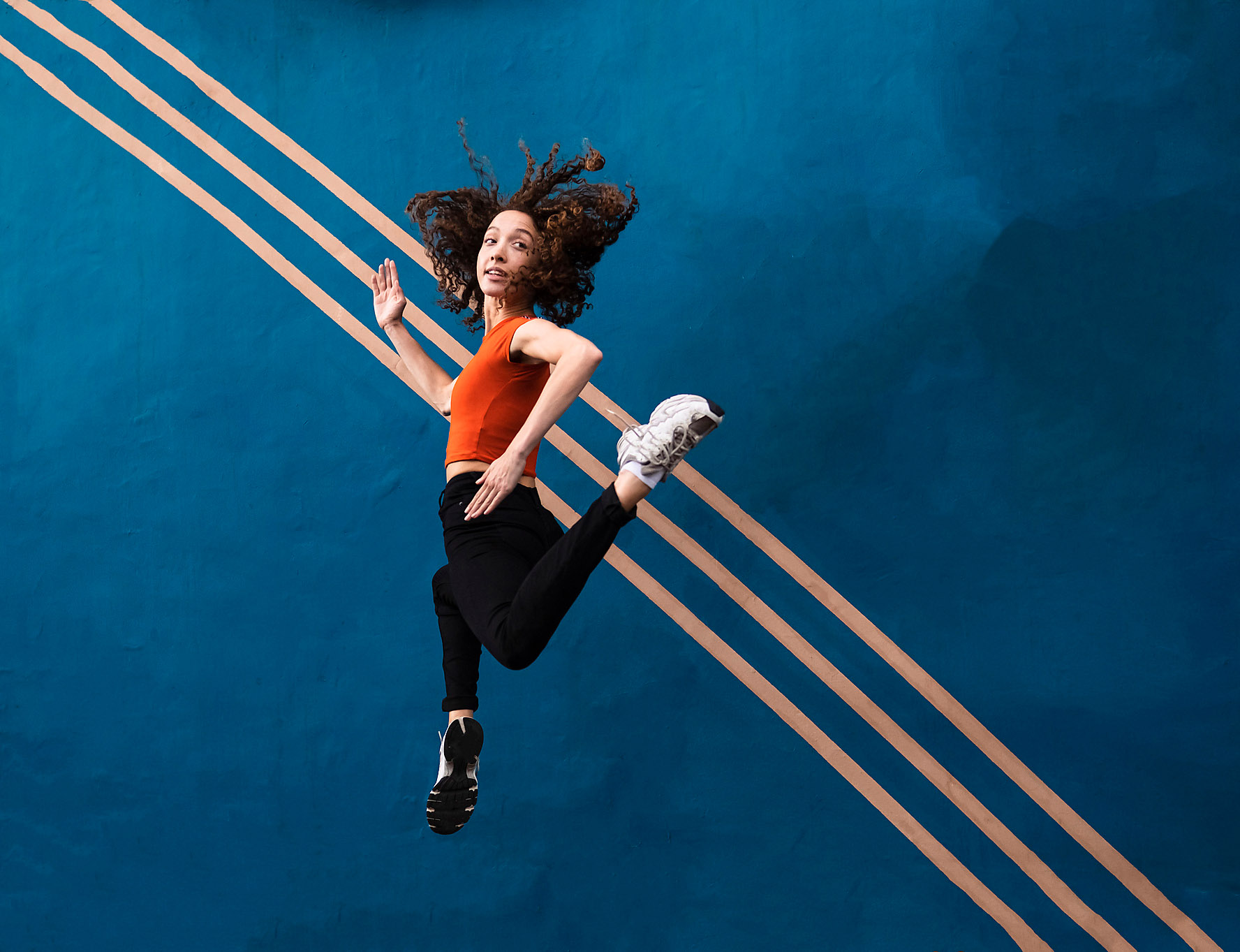 Stockfoto, lizenzfrei, echte Bilder, lebendige Bilder, VISTA Kollektion, Junge Frau springt vor einer blauen Wand