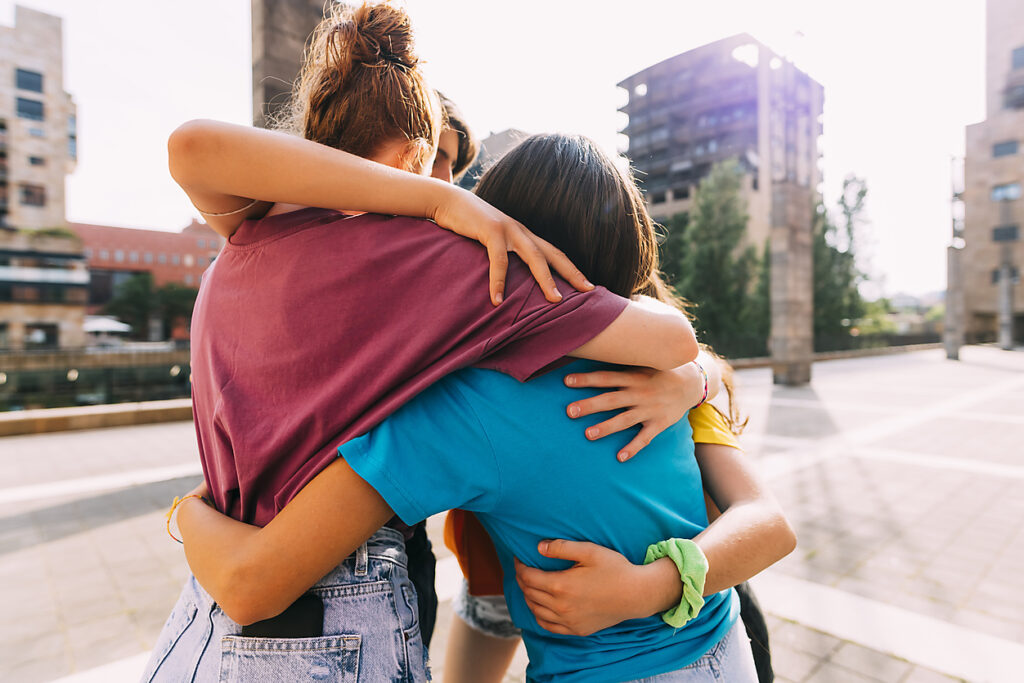 Friends hugging on a sunny day, resonance, cohesion, we-culture, togetherness, confidence, community