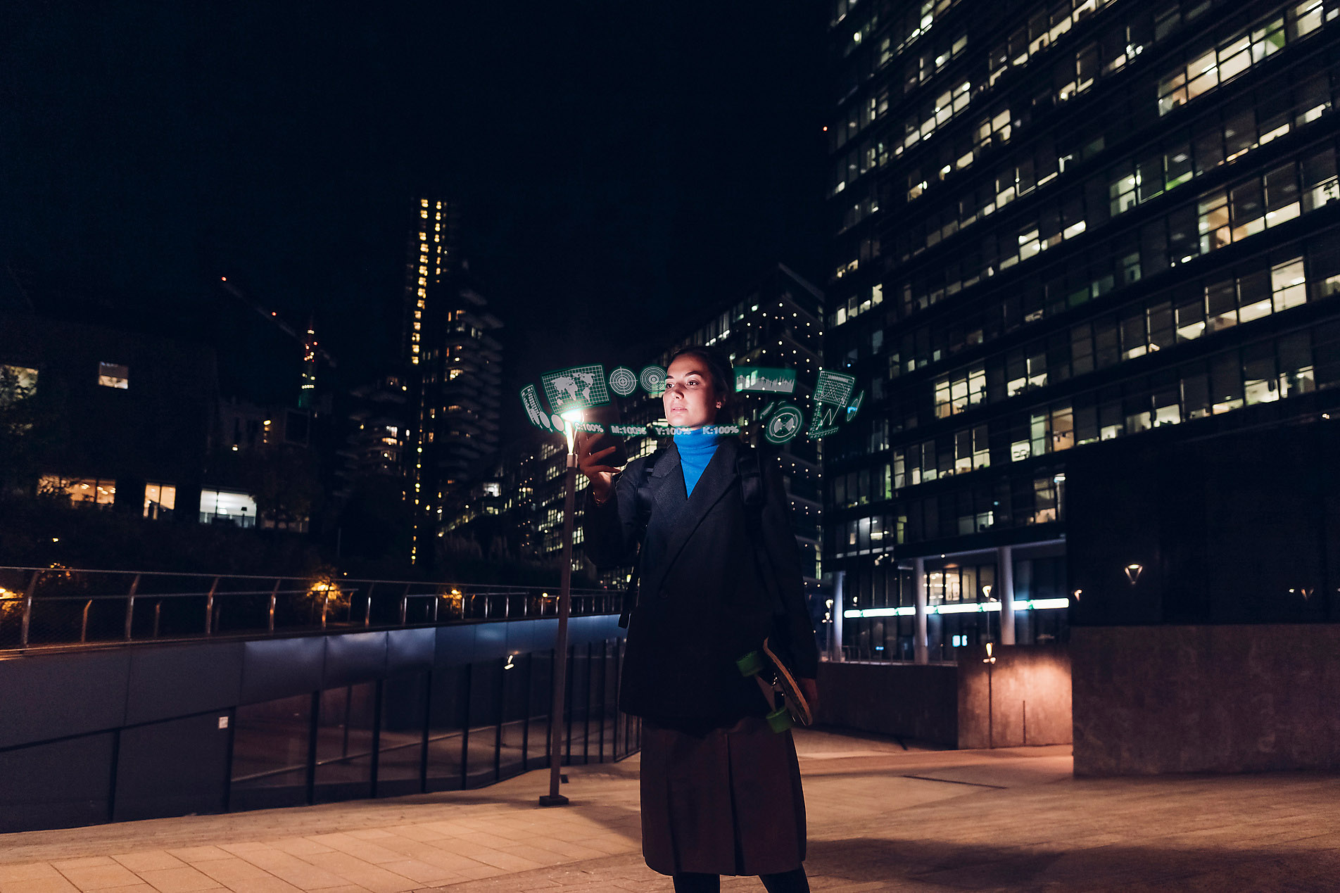 Woman using augmented reality standing on footpath at night, stock image, royalty-free, metaverse