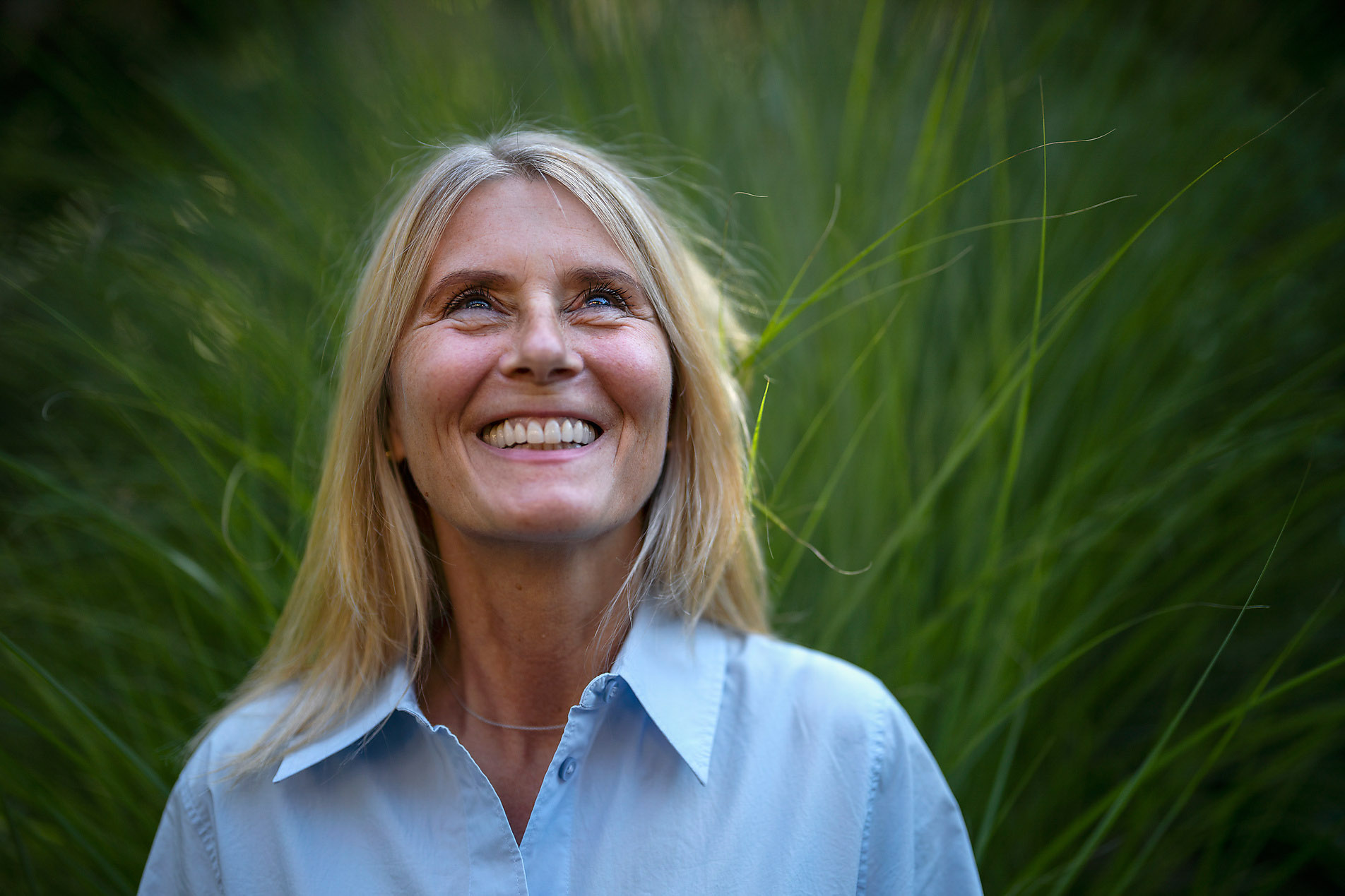 Happy mature woman standing in front of plant, Spring, season, spring, spring awakening, spring cleaning, nature, blossom, sunshine, change, new beginning, stock photo, royalty-free, Westend61