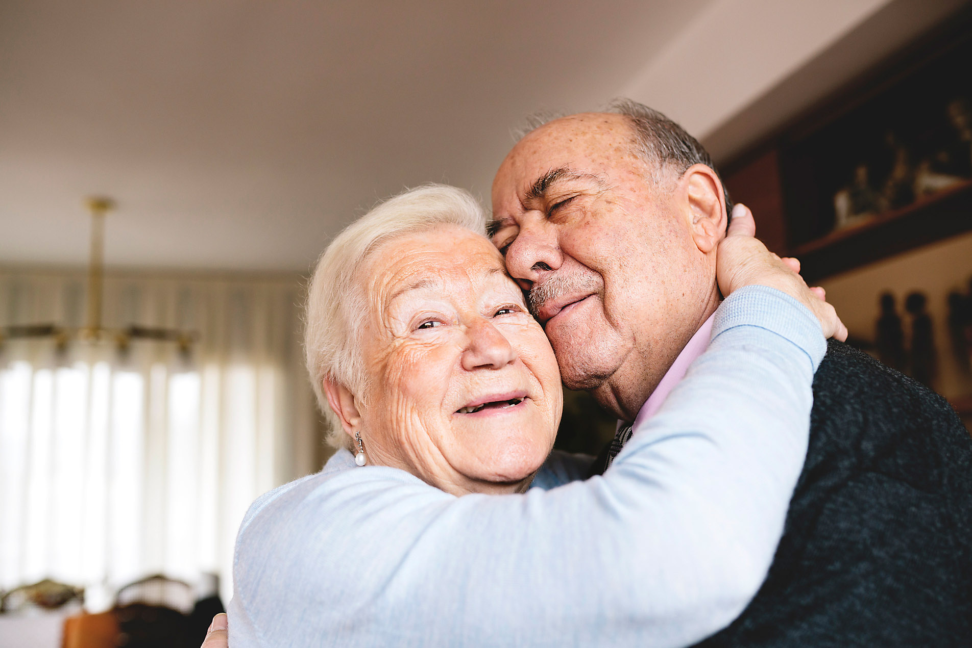Affectionate senior couple hugging at home, elderly people in love, senior love story, silver ager, best ager, digit ager, target group, westend61