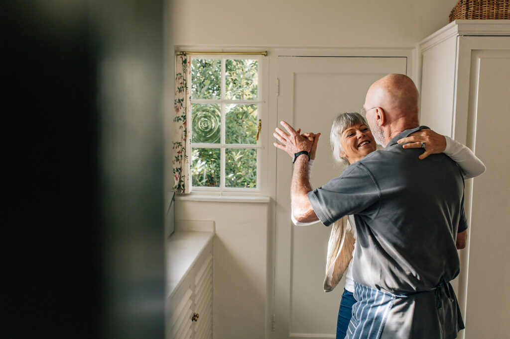 Happy elderly couple dancing together holding each other. Romantic senior couple having fun doing ballroom dancing at home., jacob lund, westend61, royalty-free, stock photo, stock content, elderly people in love, senior love story, silver ager, best ager, digit ager, target audience
