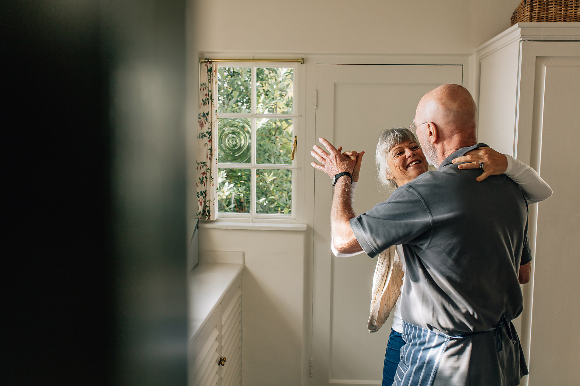 stockfoto, lizenzfrei, senioren, lovestory, liebe im alter, Glückliches älteres Paar, das zusammen tanzt und sich gegenseitig festhält. Romantisches älteres Paar, das Spaß beim Gesellschaftstanz zu Hause hat, jacob lund, westend61 stockfotgrafie, stock content