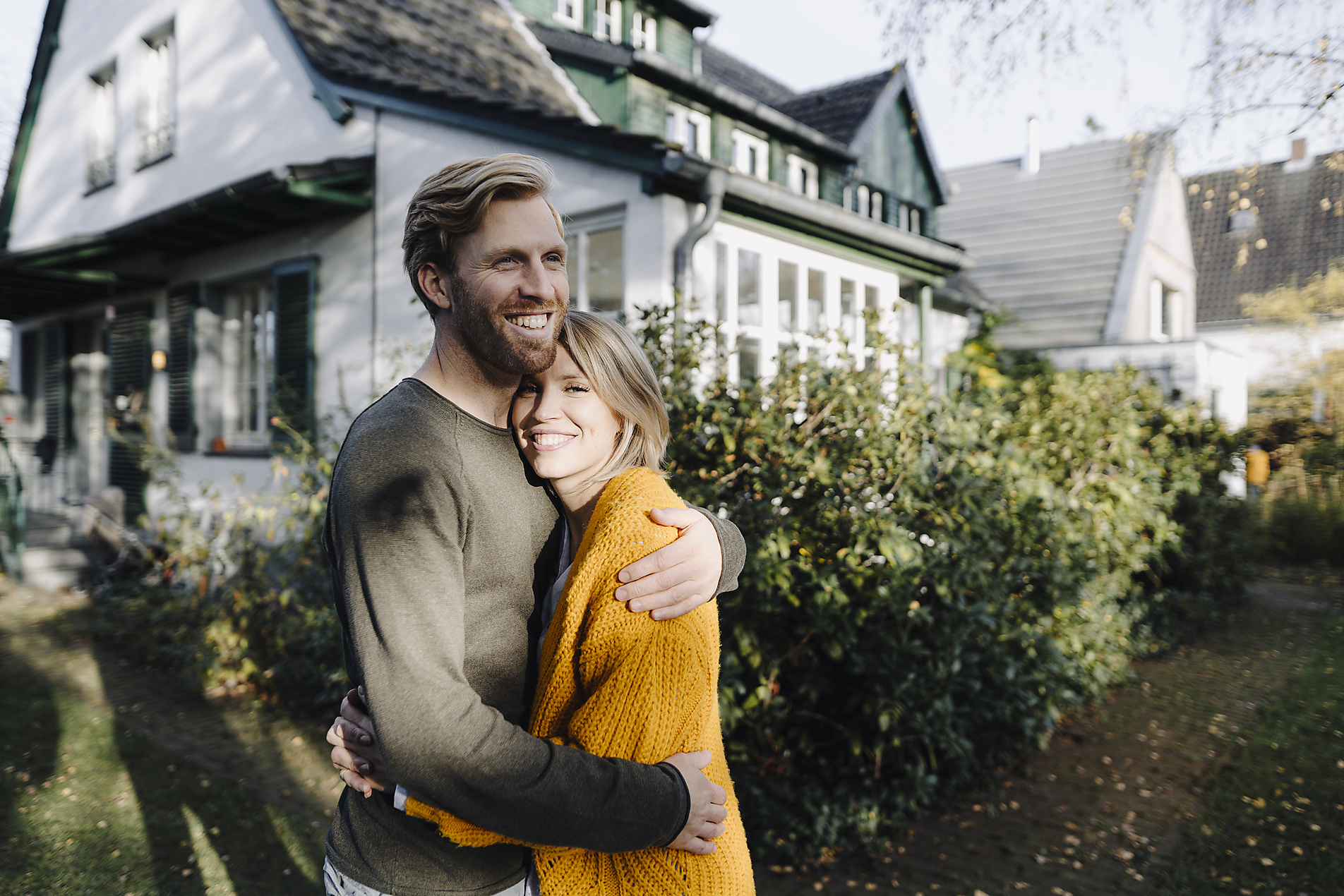 Royalty Free Stock Image of Happy couple embracing in front of their home