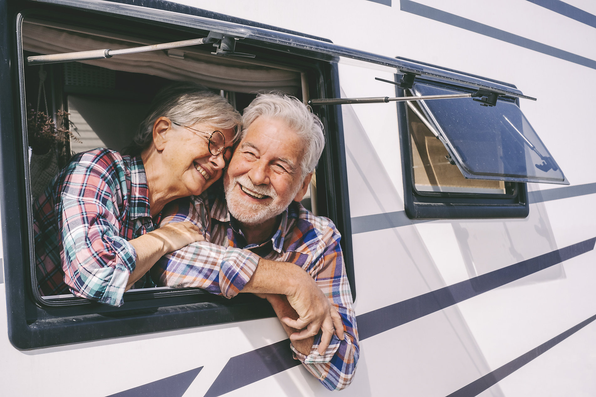 Royalty Free Stock Image of Smiling senior woman leaning on man looking through window of motor home