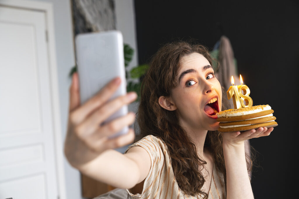 Royatly Free Stock Image of Playful young woman taking selfie with birthday cake