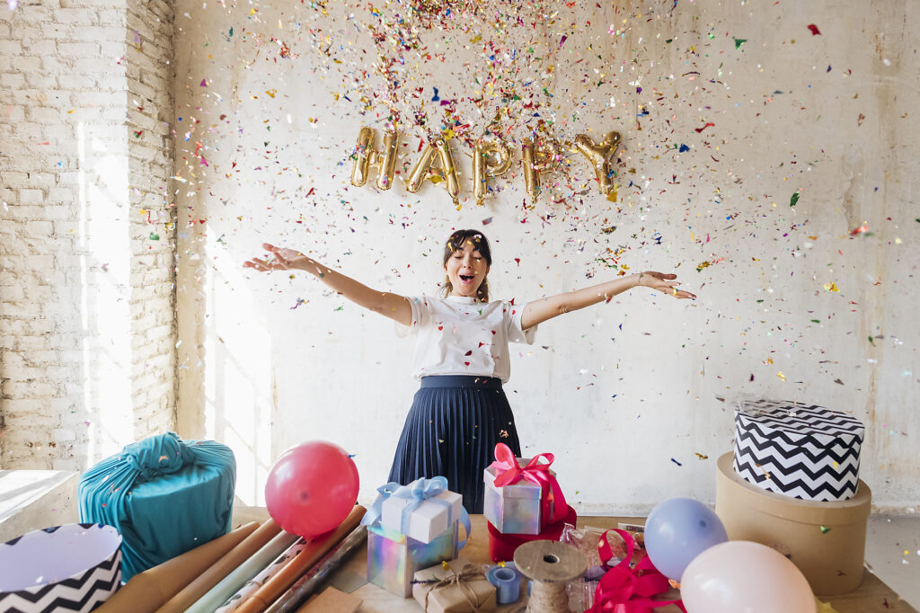 Stock Image of Happy woman enjoying under falling confetti