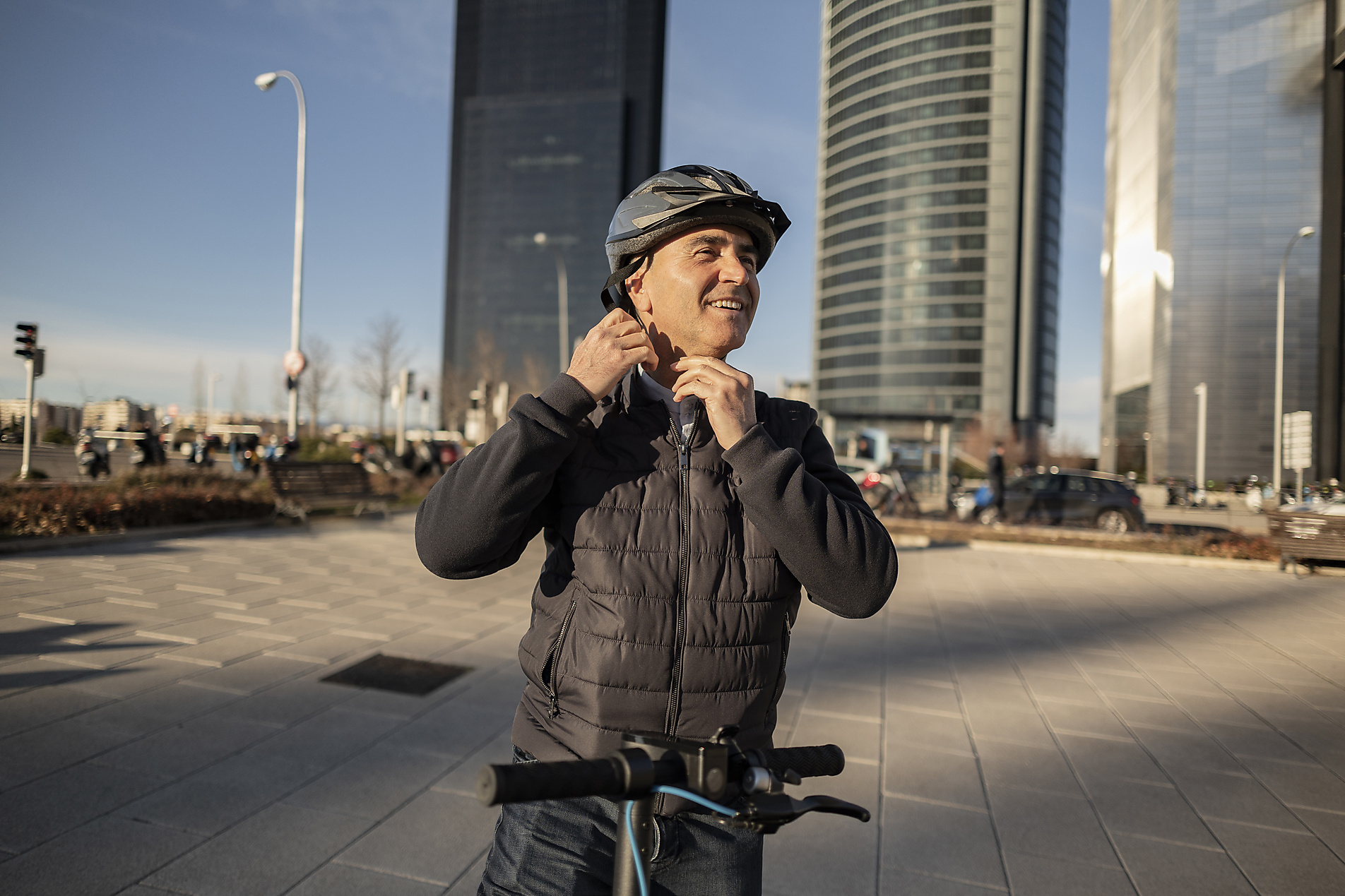 Stockimage, Royalty Free, Smiling mature businessman adjusting helmet on sunny day