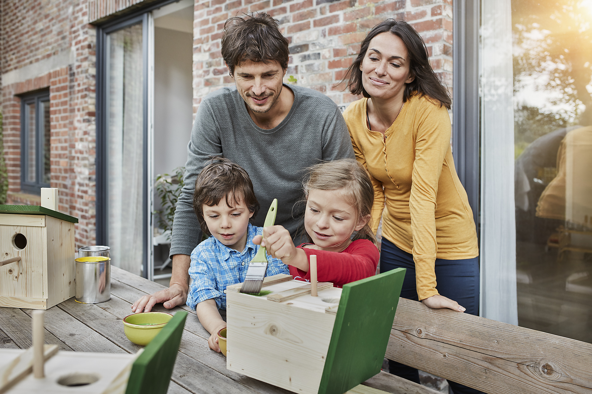 Stock Image, Royalty Free, Family working on birdhouse in front of their home