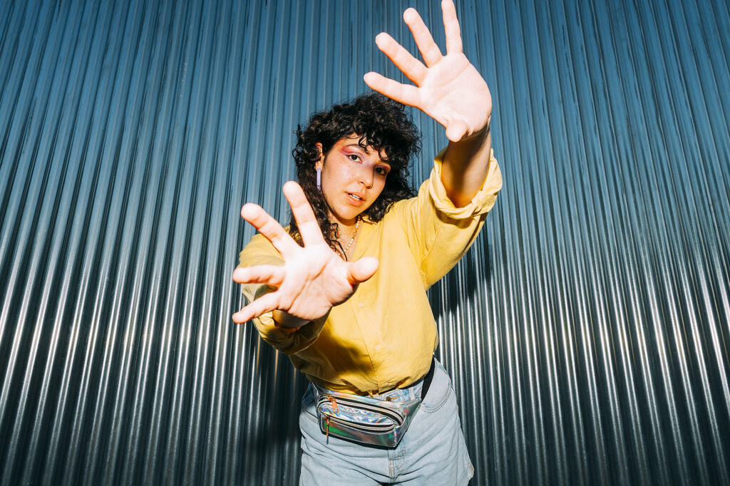 Royalty Free Stockimage of confidente woman doing stop gesture in front of corrugated wall