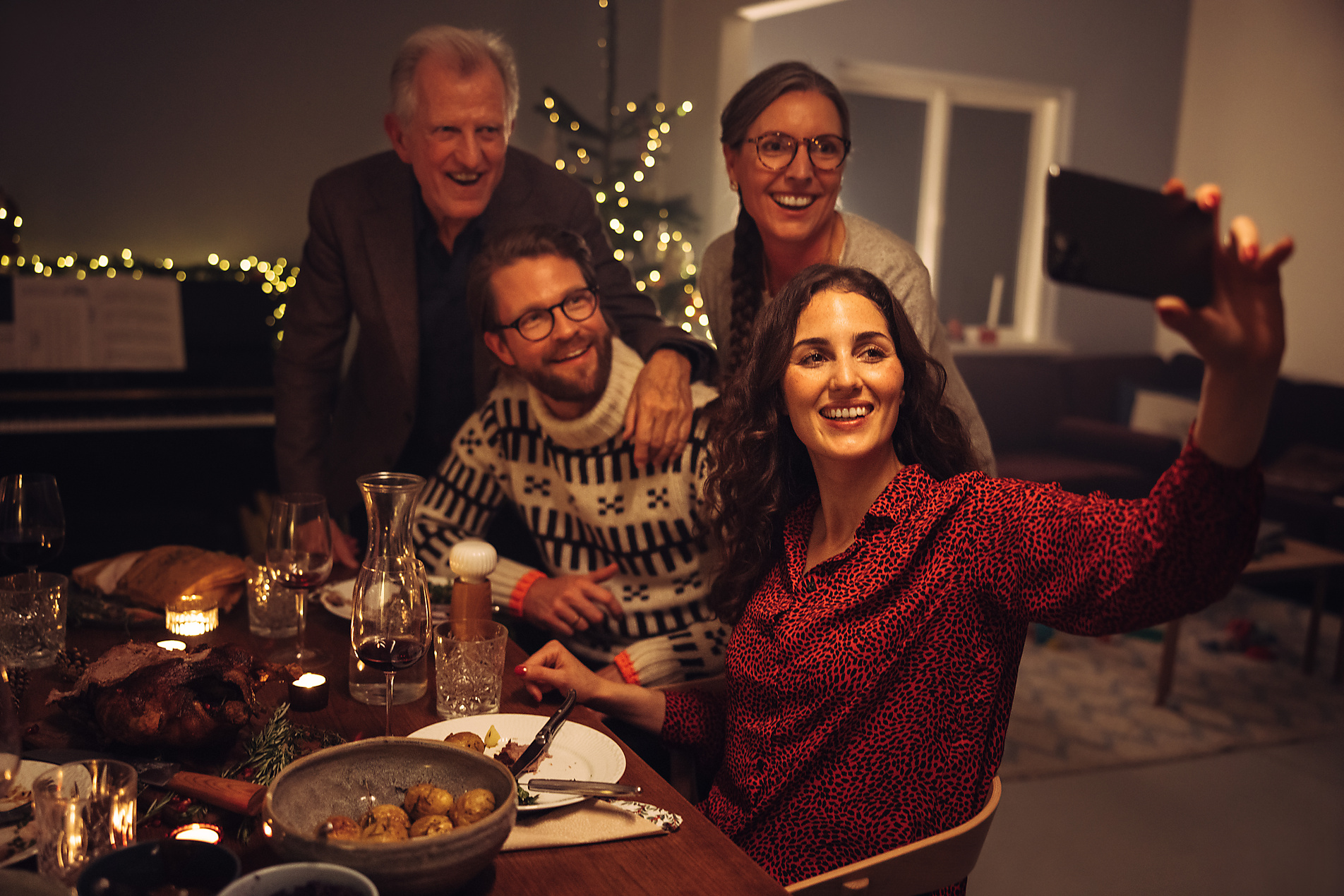Stock Image, Royalty Free, Woman taking selfie with family on christmas eve. European family taking selfie during Christmas dinner