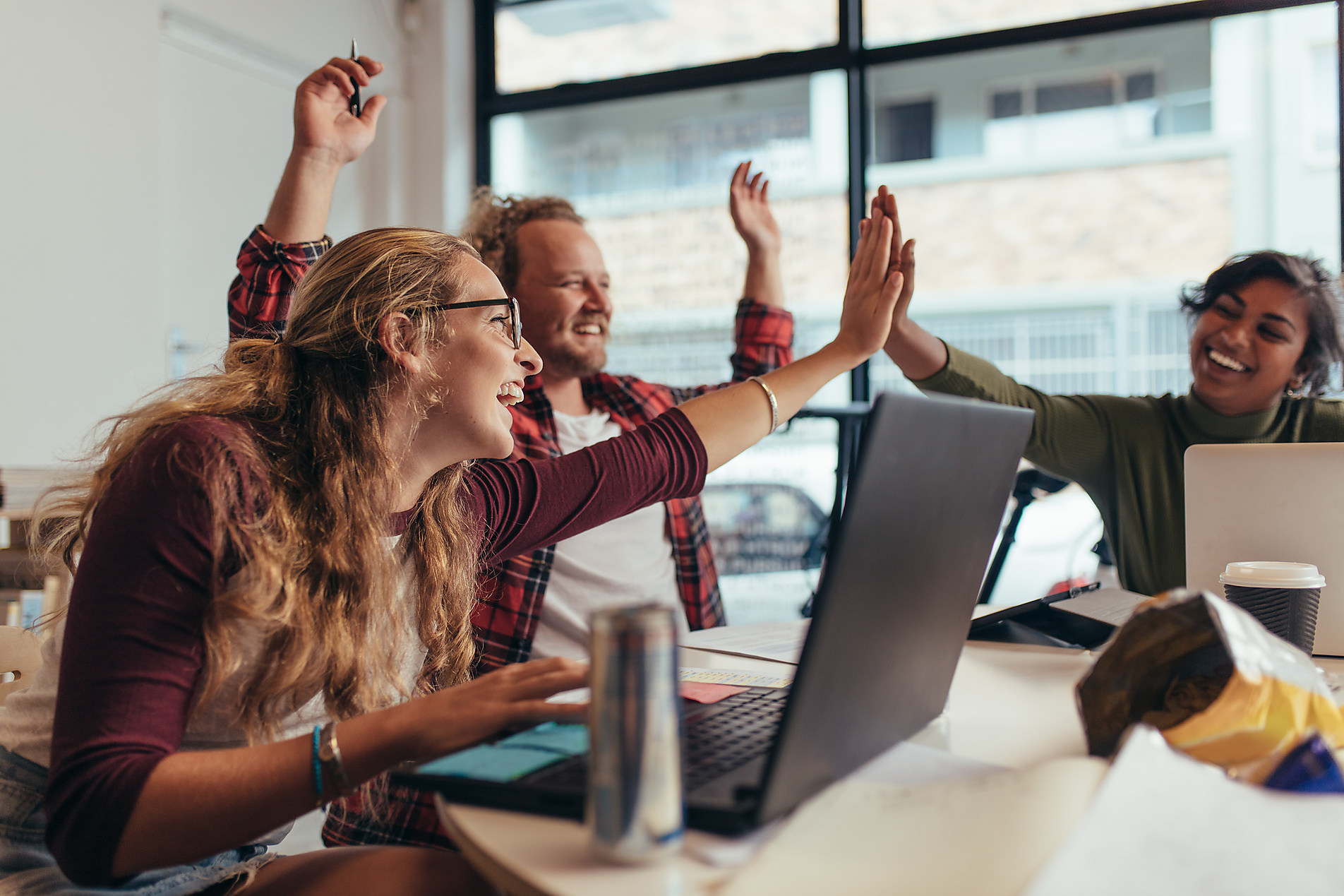 Stock Image, Royalty Free, Group of young business team giving high five and celebrating success at office. Cheerful startup business team rejoicing success at office