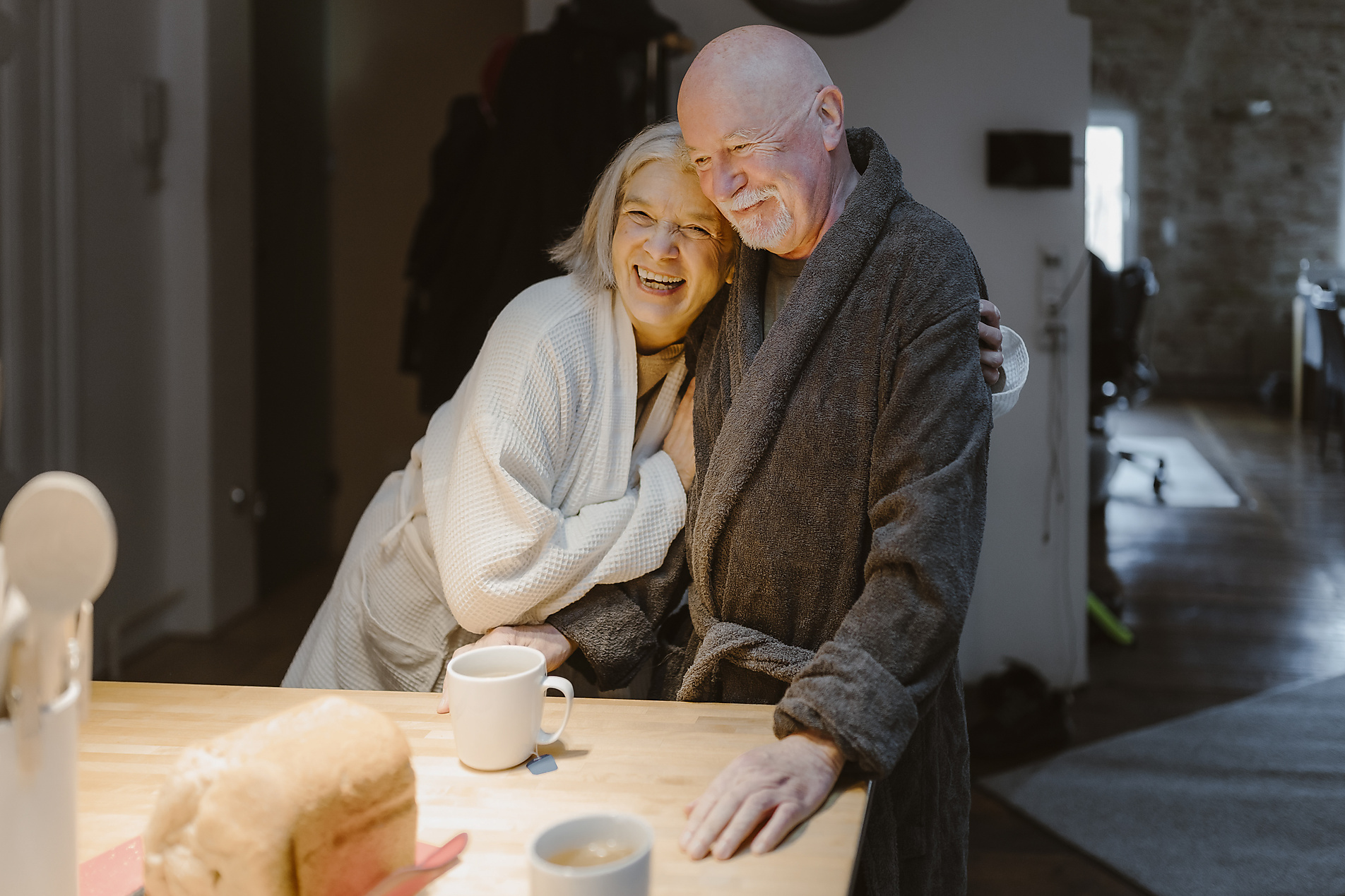 Stock Image, Royalty Free, Happy senior woman embracing man wearing bathrobe at home