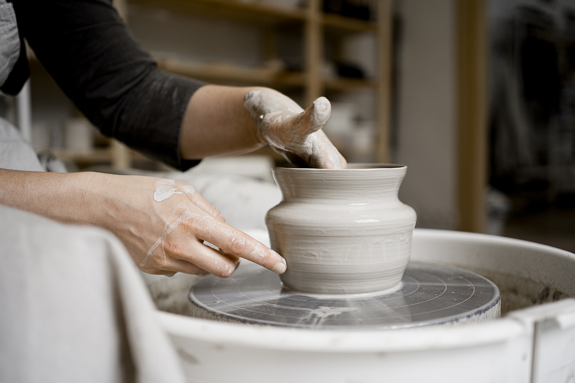 Stock Image, Royalty Free, Young craftswoman making flower pot on pottery wheel