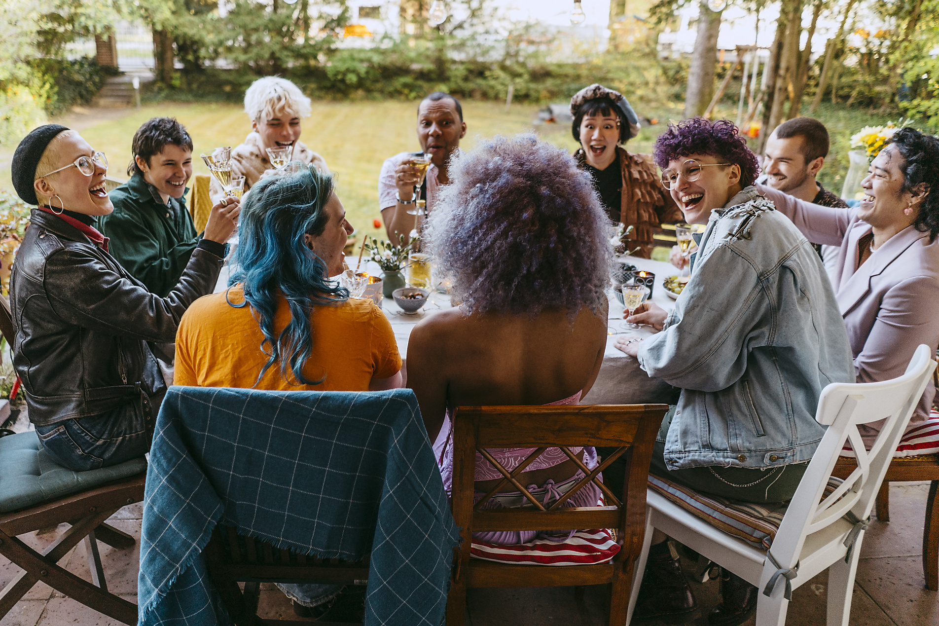 Stock image, royalty free stock photo, Happy friends of LGBTQ community cheering during dinner party in back yard