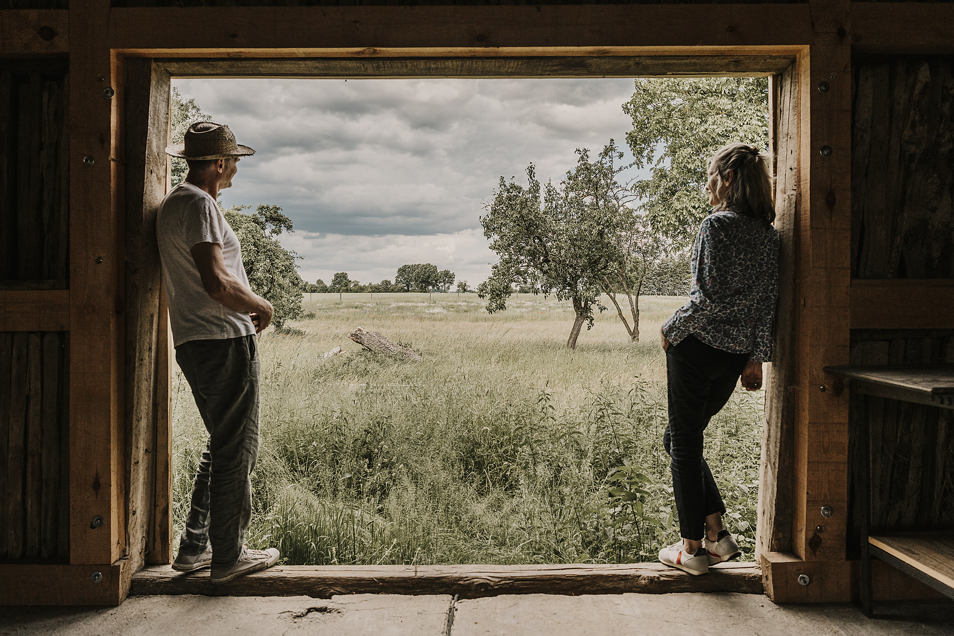 Stock image, royalty free stock photo, Man and woman looking at field leaning on doorway