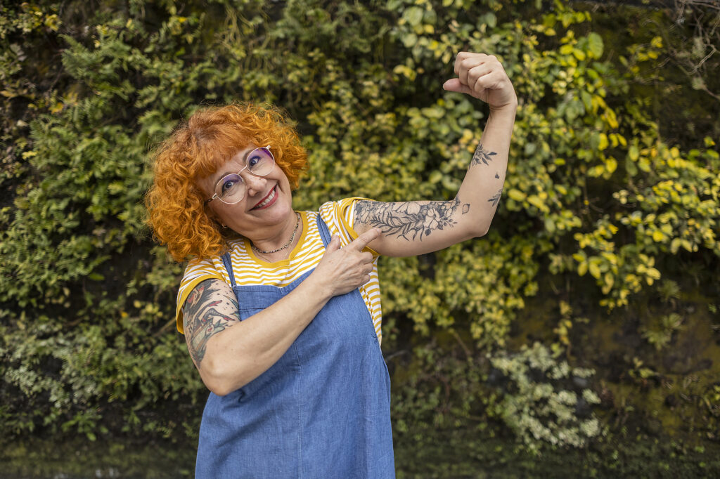 Smiling redhead senior woman flexing muscles with tattoo on it Royalty free image Smiling redhead senior woman flexing muscles with tattoo on it
Royalty free image