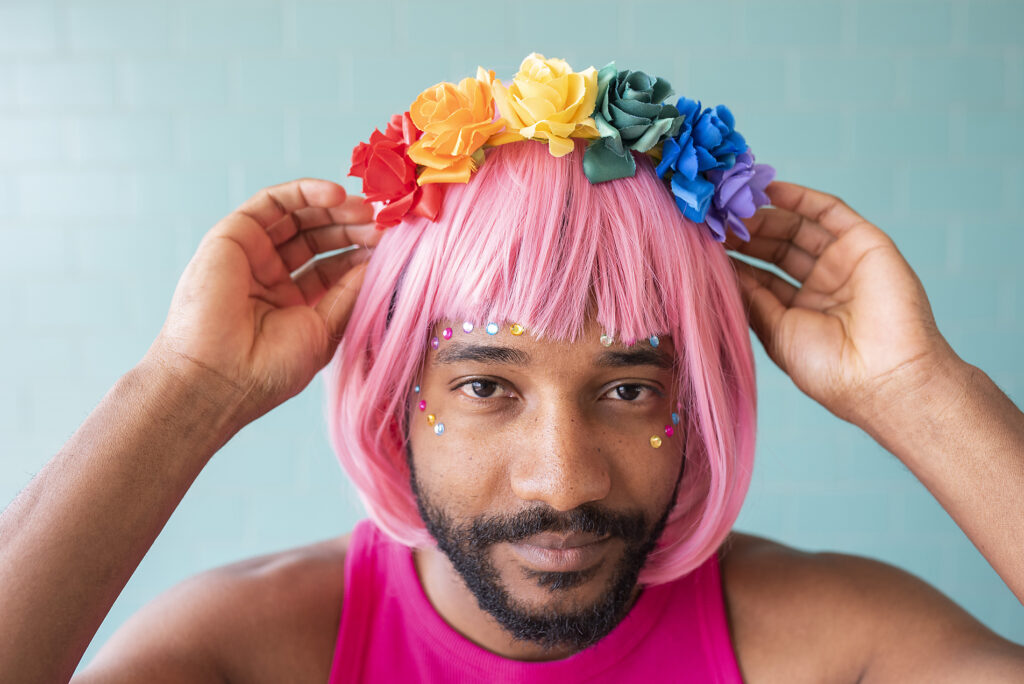 Young queer man adjusting flower tiara on pink wig Royalty free image Young queer man adjusting flower tiara on pink wig
Royalty free image