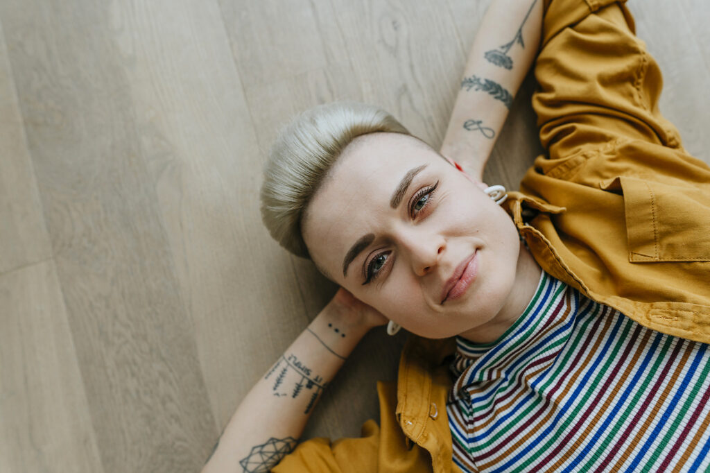 Smiling hipster woman lying down on hardwood floor Royalty free image Smiling hipster woman lying down on hardwood floor
Royalty free image