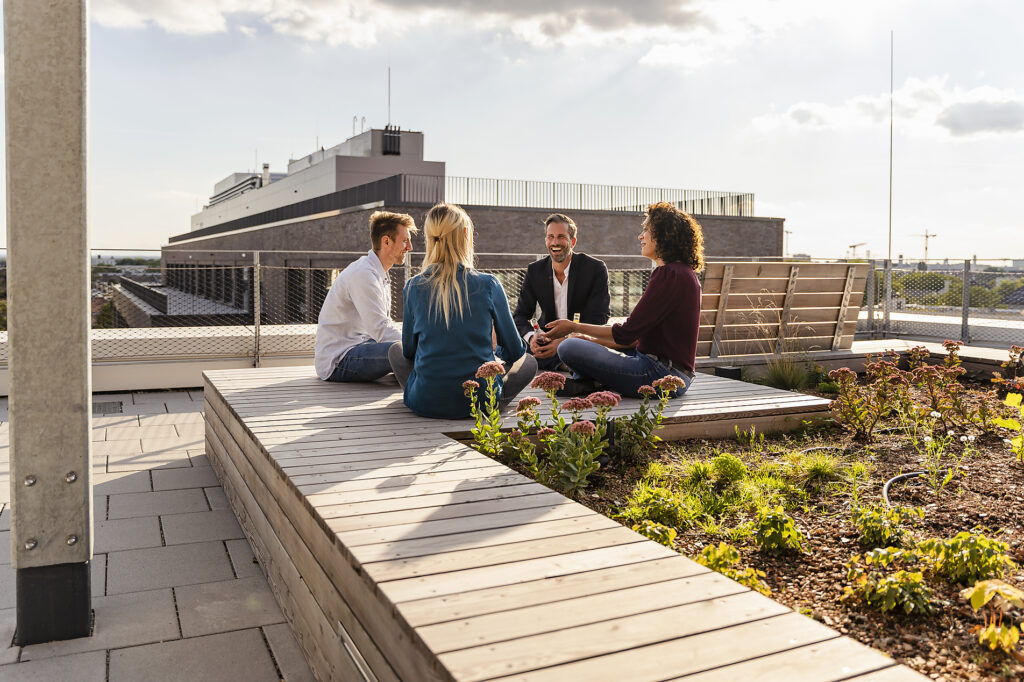 Coworkers with cross-legged sitting on rooftop Stockphoto Coworkers with cross-legged sitting on rooftop Stockphoto