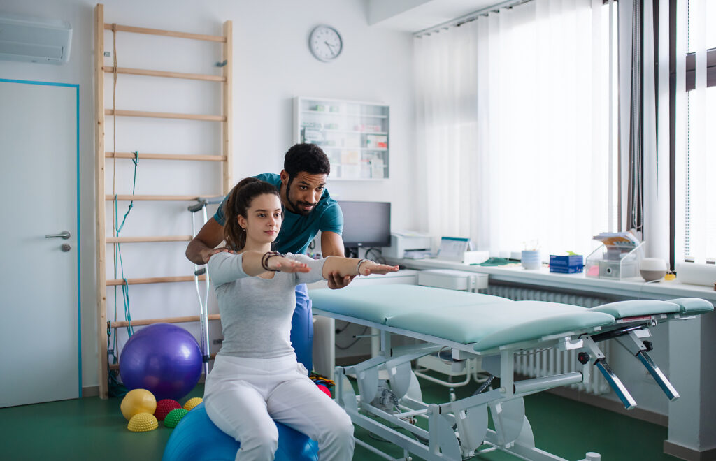 Ein junger männlicher Physiotherapeut übt mit einer jungen Patientin auf einem Ball in einem Krankenzimmer
Lizenzfreies Stockfoto
