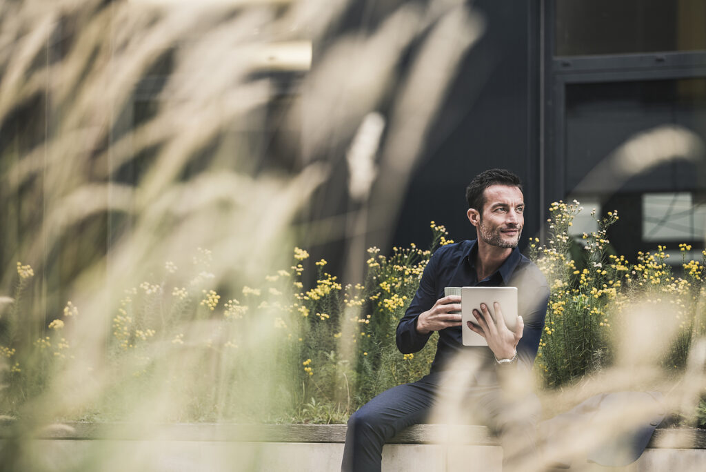Businessman sitting outside, taking a break, drinking coffee, using digital tablet Stockphoto Businessman sitting outside, taking a break, drinking coffee, using digital tablet Stockphoto