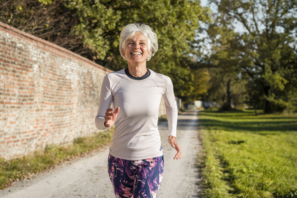 Happy senior woman running along brick wall in a park
Royalty free image