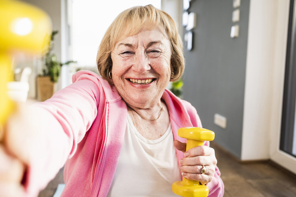 Cheerful senior woman working out with yellow dumbbells at home
Royalty free image