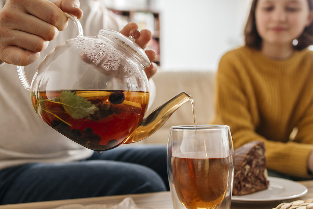 Mann gießt Tee in Glas in der Nähe der Tochter zu Hause
Lizenzfreies Stockfoto