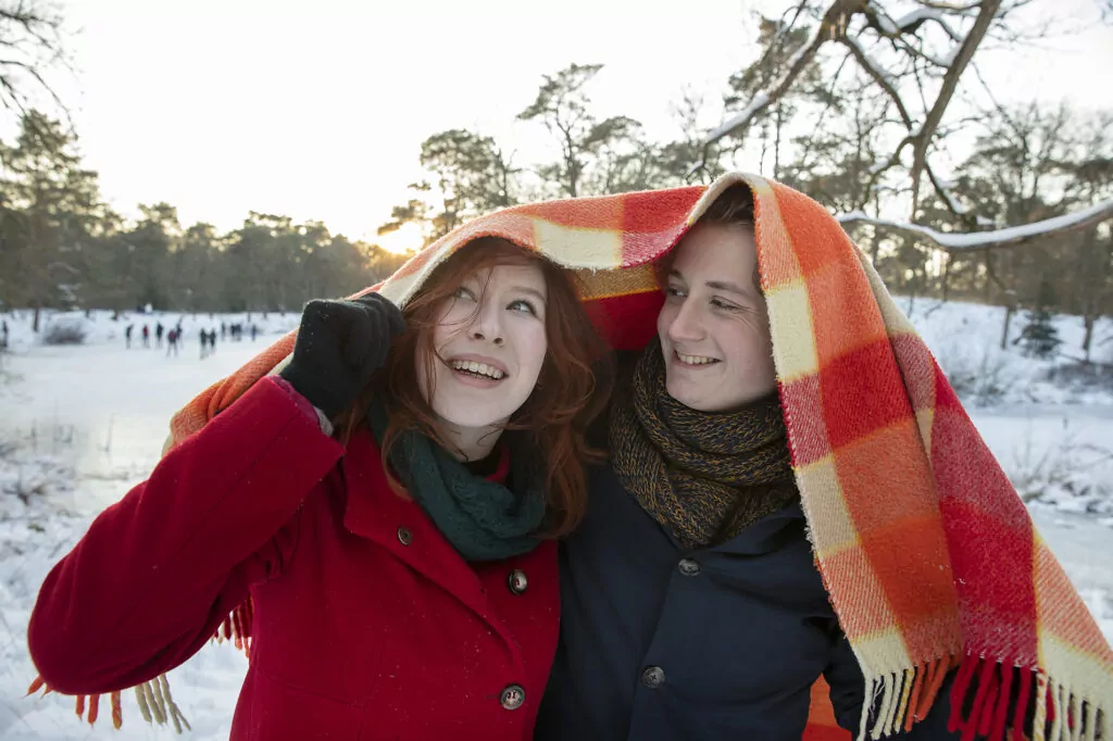 Smiling couple covering head with blanket during winter
Royalty free image