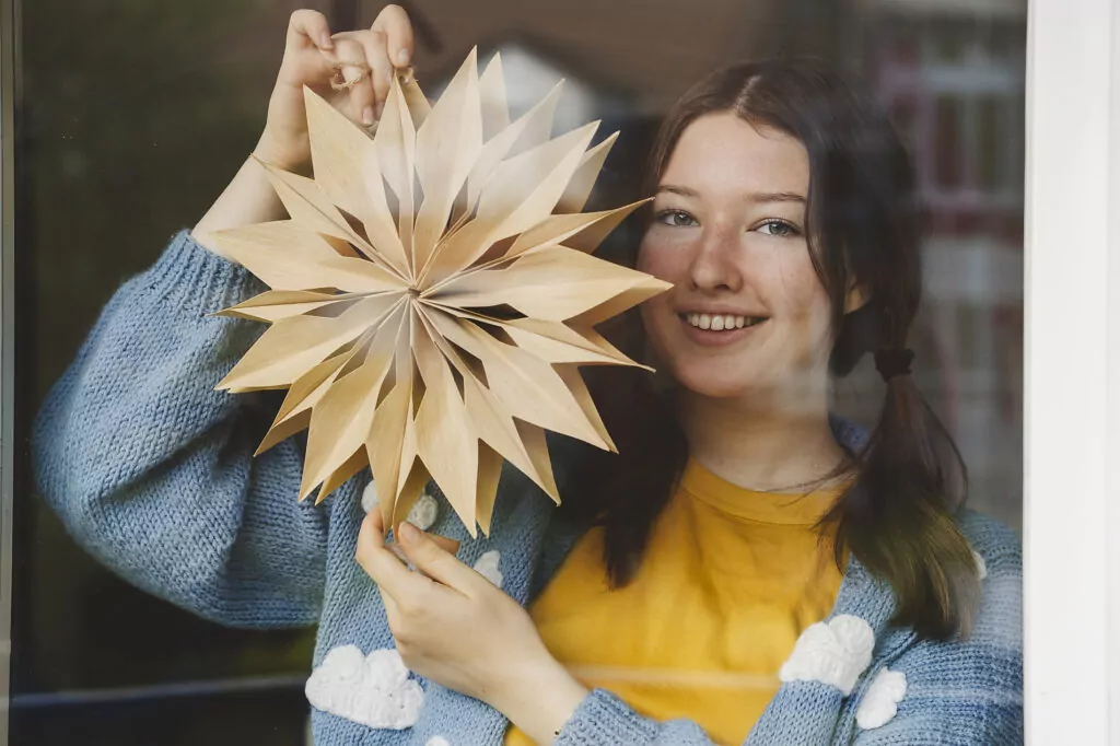 Smiling girl holding star shaped Christmas decoration seen through glass
Royalty free image