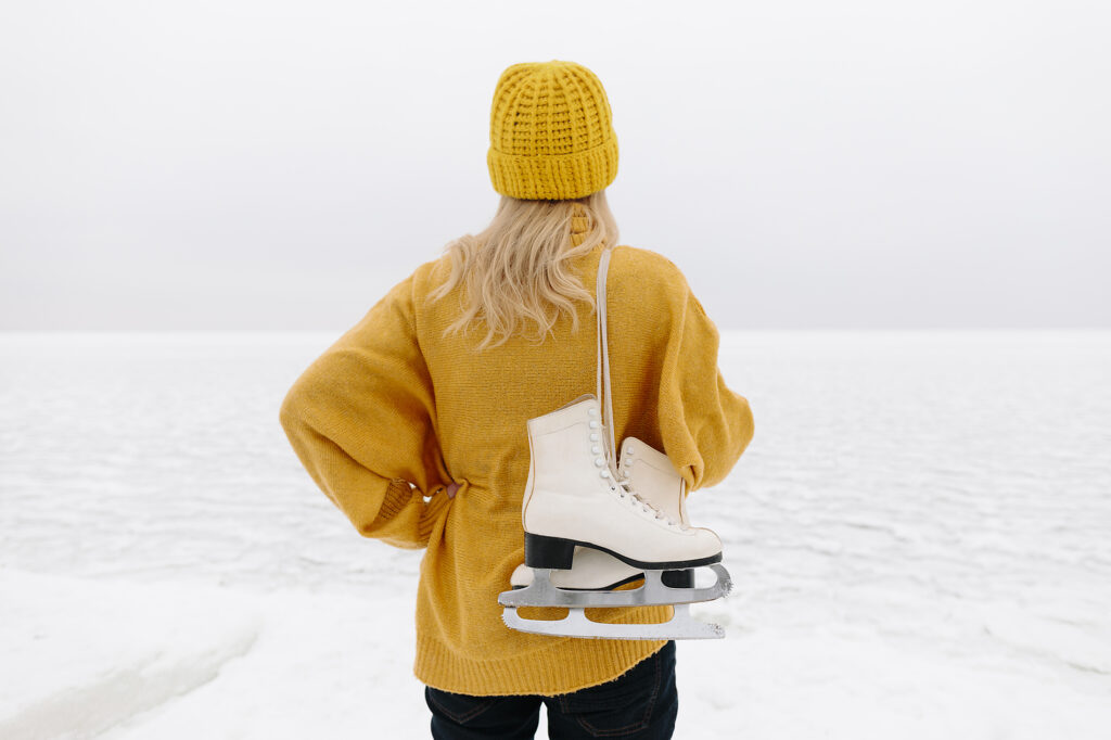 Frau in warmer Kleidung steht mit Schlittschuhen vor dem Wintermeer
Lizenzfreies Stockfoto