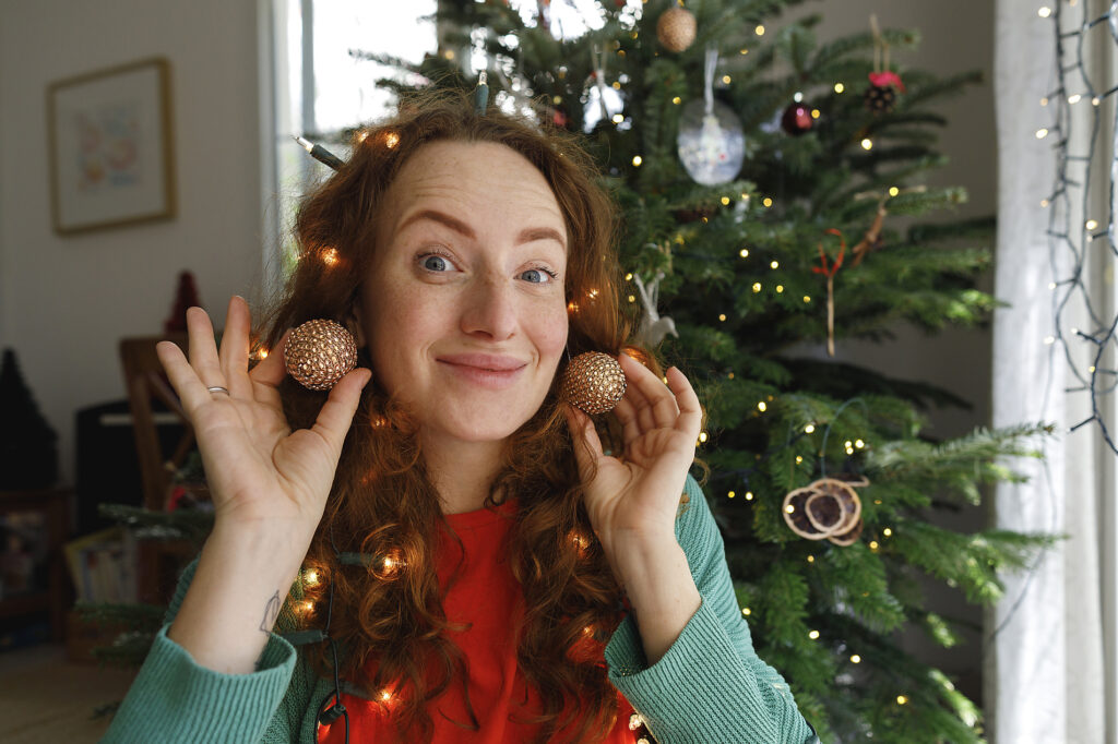 Lächelnde Frau mit Ohrringen vor einem Weihnachtsbaum
Lizenzfreies Stockfoto