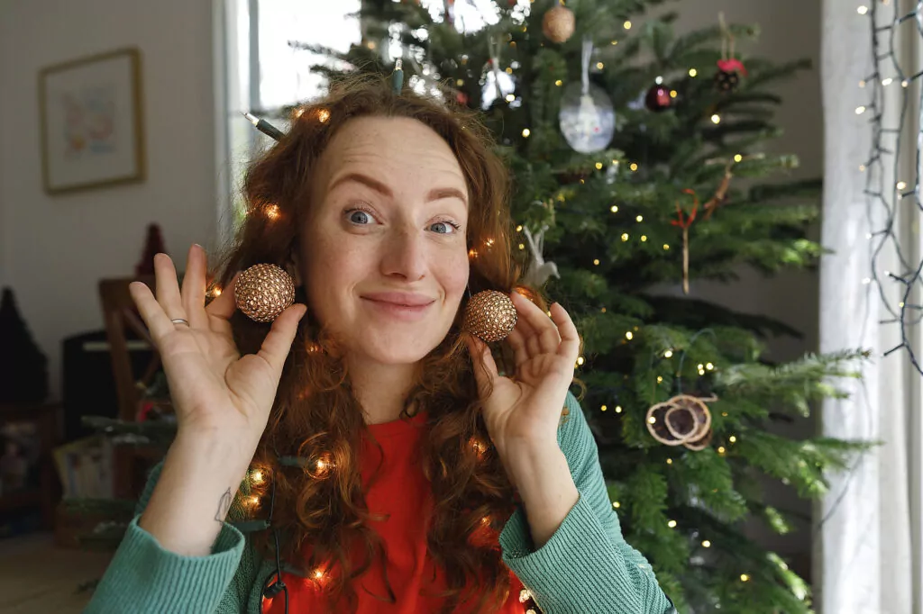 Smiling woman with earrings in front of Christmas tree
Royalty free image