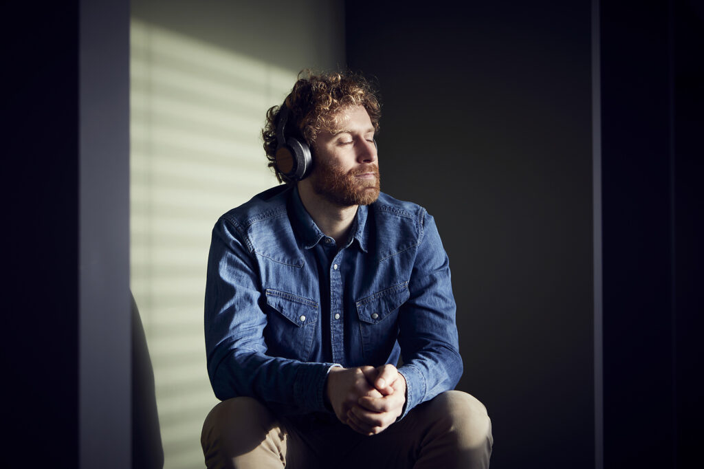 Relaxed casual businessman sitting down listening to music with headphones
Royalty free image
