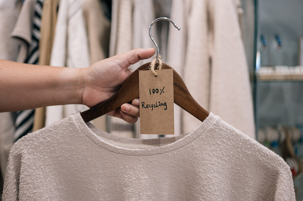 Close up view of hand holding a hanger with a recycled sweater in a boutique. Lizenzfreies Stockfoto Close up view of hand holding a hanger with a recycled sweater in a boutique.
Lizenzfreies Stockfoto