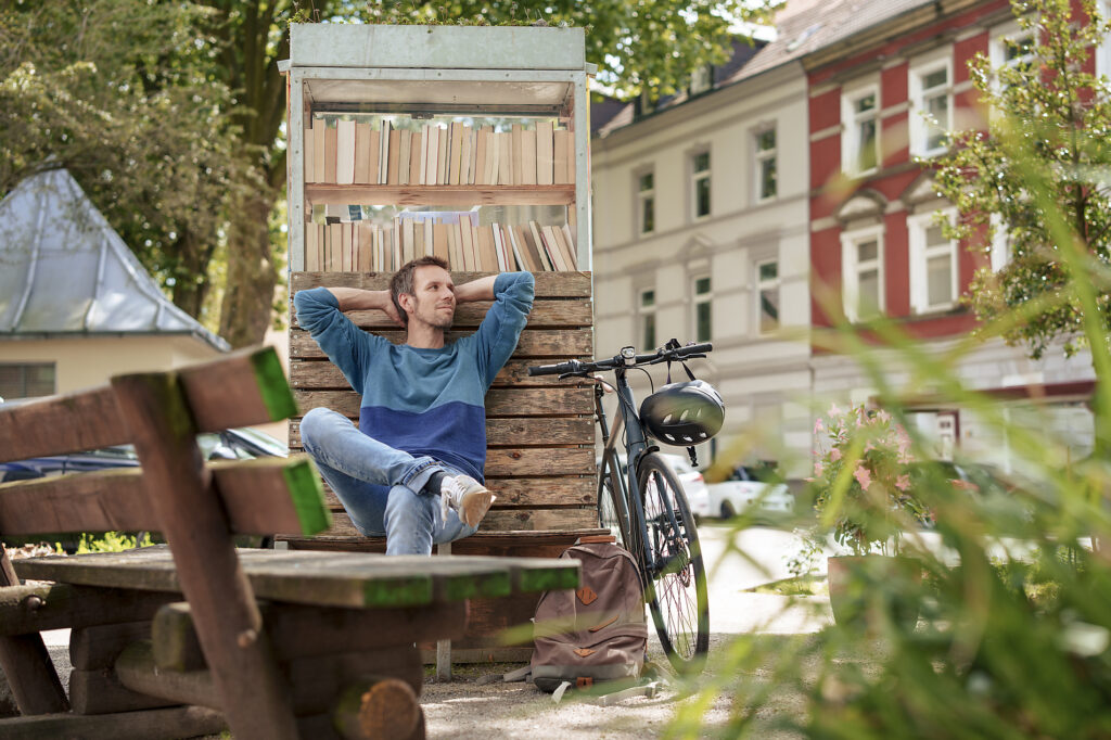 Contemplative man leaning on cabinet with books near bicycle
Royalty free image