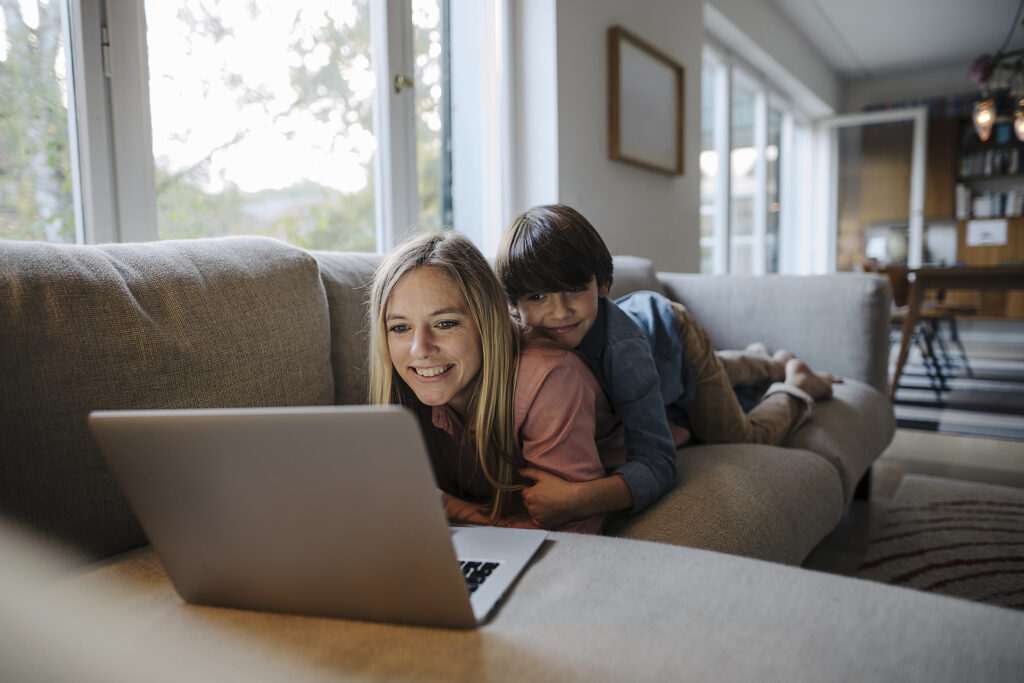 Mother and son lying on couch, using laptop
Royalty free image