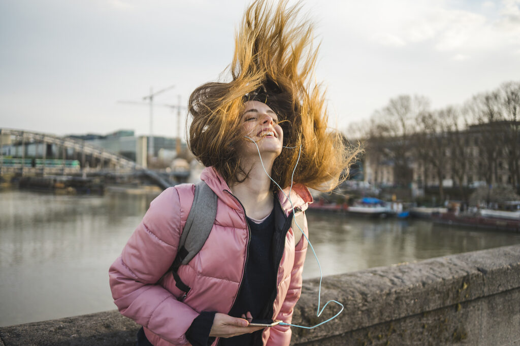 Paris, Frankreich, glückliche junge Frau, die mit Kopfhörern und Smartphone Musik hört und ihr Haar wirft
Lizenzfreies Stockfoto