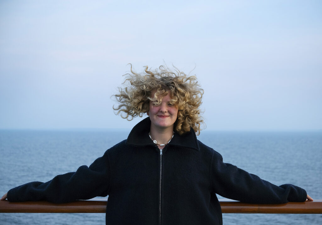 Mädchen mit zerzaustem Haar und Jacke unter blauem Himmel
Lizenzfreies Stockfoto