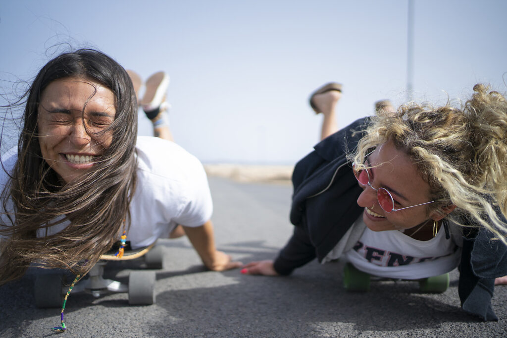 Freunde, die Spaß haben, indem sie auf dem Skateboard vorne liegen
Lizenzfreies Stockfoto