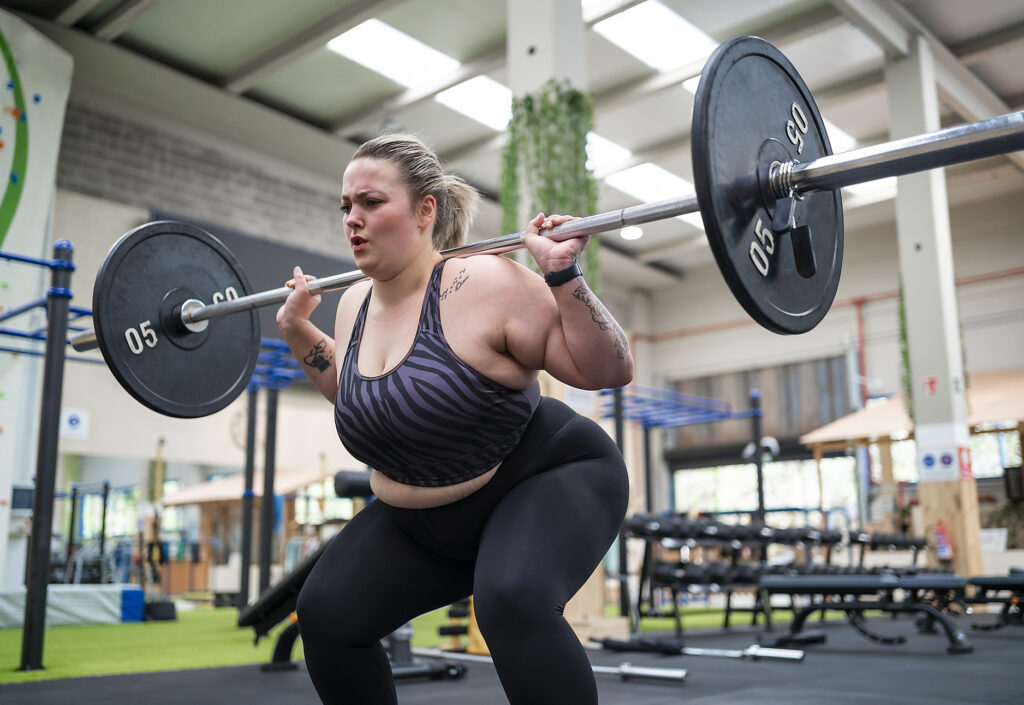 Overweight woman doing squats with barbell in gym Royalty-free image Overweight woman doing squats with barbell in gym
Royalty-free image