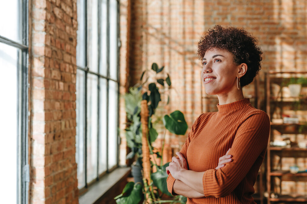 Confident professional smiling and looking out window in modern office Royalty-free image Confident professional smiling and looking out window in modern officeRoyalty-free image