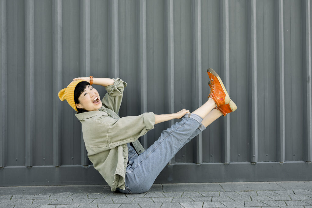 Laughing woman in casual urban outfit sitting playfully by gray wall Royalty-free image Laughing woman in casual urban outfit sitting playfully by gray wall
Royalty-free image