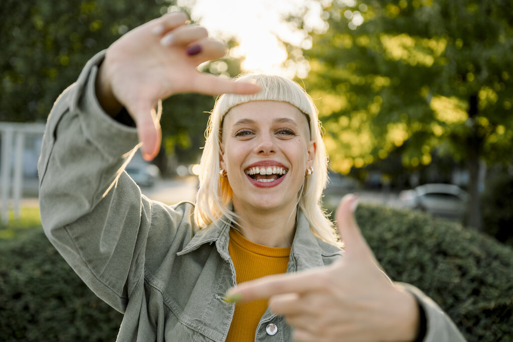Lächelnder Hipster, der eine Rahmengeste im Freien in einer städtischen Lifestyle-Umgebung macht Lizenzfreies Stockfoto Lächelnder Hipster, der eine Rahmengeste im Freien in einer städtischen Lifestyle-Umgebung machtLizenzfreies Stockfoto
