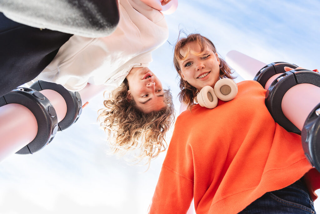 Friends looking down at camera against blue sky in summer
Royalty-free image