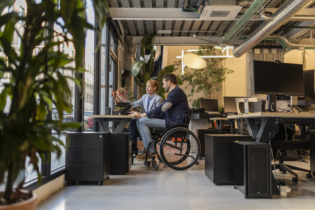 Businesswoman discussing with colleague in wheelchair at office
Royalty-free image